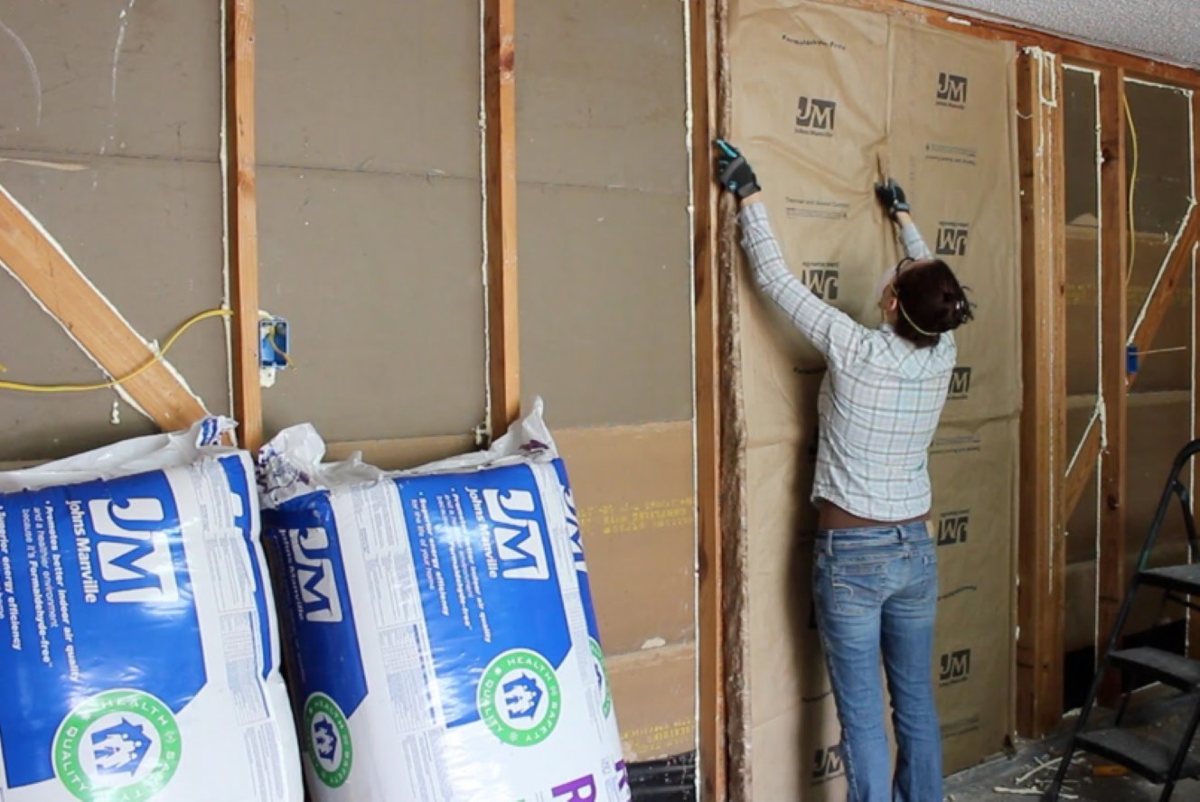 man installing insulation inside a garage